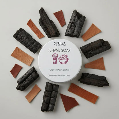 Stuga Australia Shave Soap with Charred Oak and Leather scent, 80g, surrounded by charcoal pieces and leather swatches.