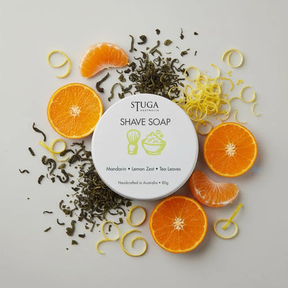 Stuga Australia shave soap with mandarin, lemon zest, and tea leaves, surrounded by orange slices and lemon peels.