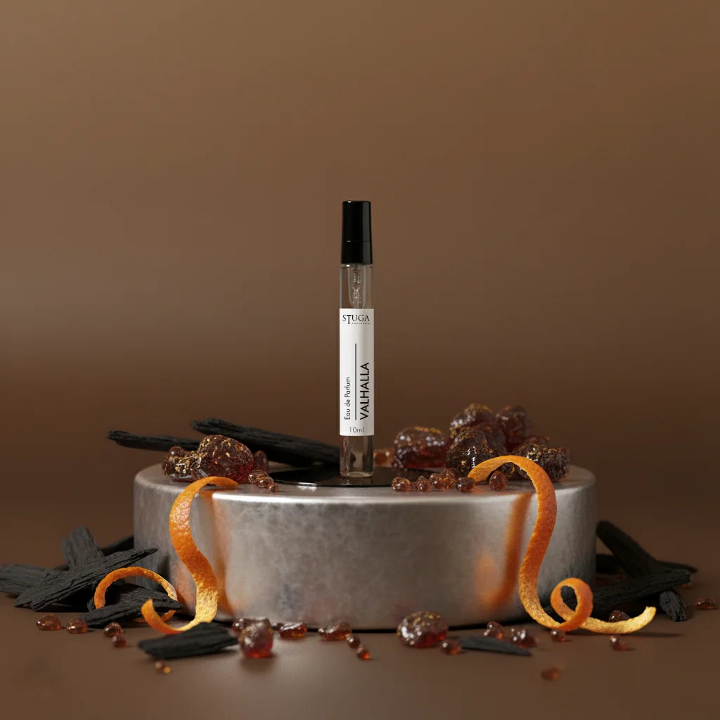 Stuga Valhalla Eau de Parfum 10ml travel spray bottle on a metal stand with orange peels and dark wood chips.