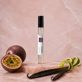 Stuga Vanilla No. 313 vanilla perfume, 10ml eau de parfum spray bottle on pink marble with halved passionfruit, orange zest and vanilla beans.