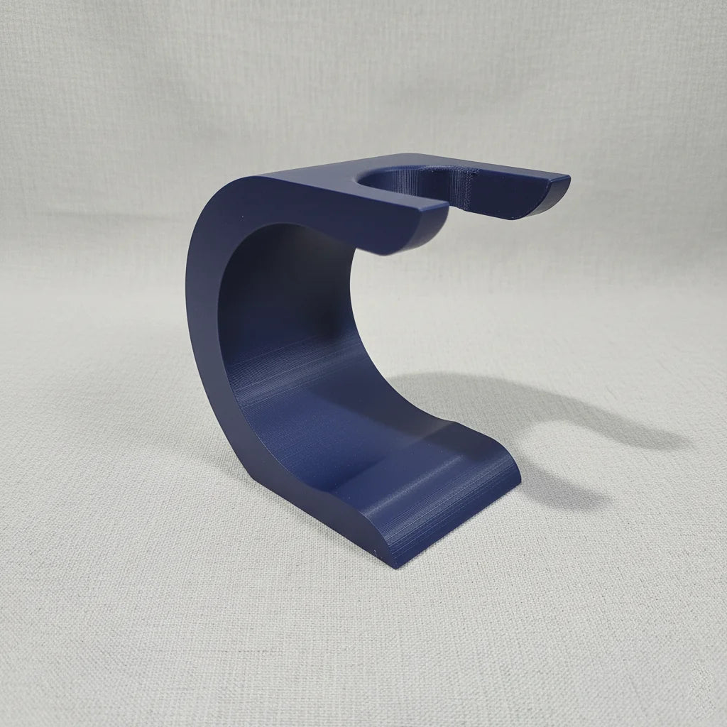 Dark blue Stuga Wave shaving brush stand, C-shaped, for drying and displaying shaving brushes.