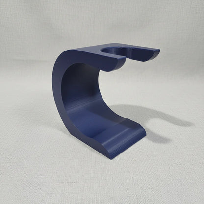 Dark blue Stuga Wave shaving brush stand, C-shaped, for drying and displaying shaving brushes.
