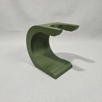 Stuga Wave shaving brush stand in matte olive green, featuring a modern curved design for elegant bathroom organization.