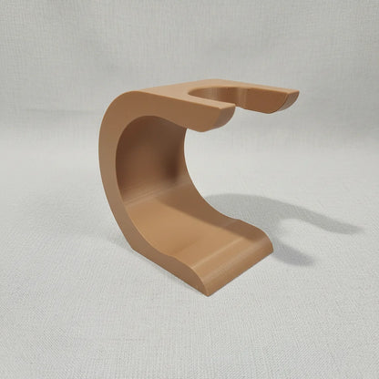 Stuga Wave shaving brush stand in a light brown, matte finish, designed to hold a shaving brush upside down for drying.