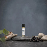 Stuga White Musk No. 421 white musk oil perfume, 10ml roll-on bottle on a slate slab, with silver birch bark, fresh blackcurrants and smooth pale stones.