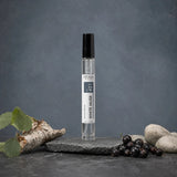 Stuga White Musk No. 421 white musk perfume, 10ml eau de parfum spray bottle on a slate slab, with silver birch bark, fresh blackcurrants and smooth pale stones.