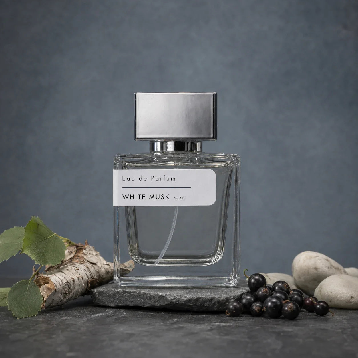 Stuga White Musk No. 421 white musk perfume, 50ml eau de parfum bottle with a silver cap on a slate slab, with silver birch bark and leaves, fresh blackcurrants and smooth pale stones.