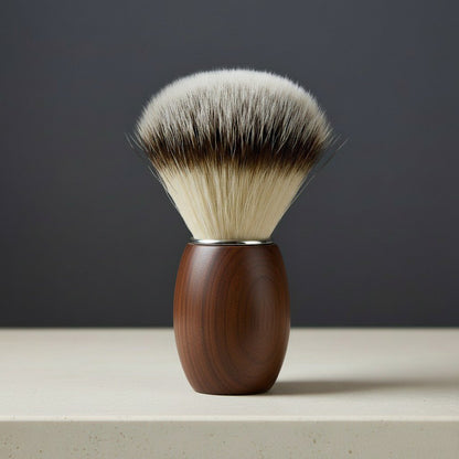Walnut wood shaving brush with soft, two-tone synthetic bristles and a silver collar, standing upright.