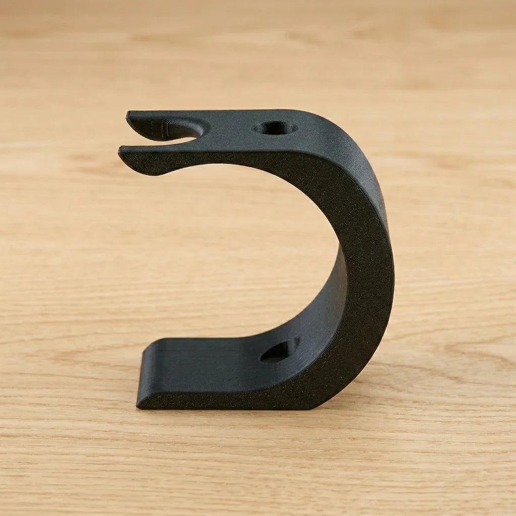 Black matte Wave XL shaving kit stand with curved C-shape design, forked razor holder on top, on wood surface