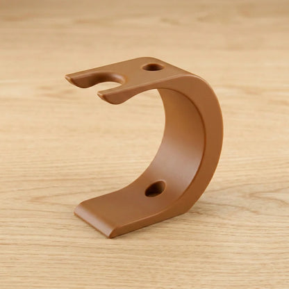 Brown curved Wave XL shaving kit stand with razor and brush holder notches on a wooden surface